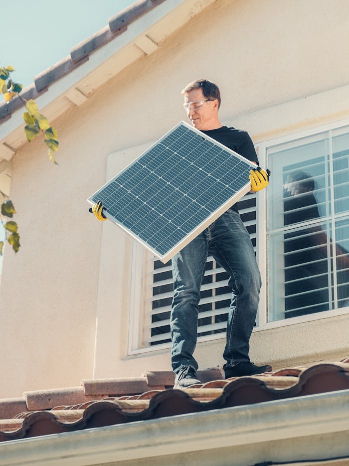 About A technician is installing a solar panel on a house roof, promoting clean energy solutions.